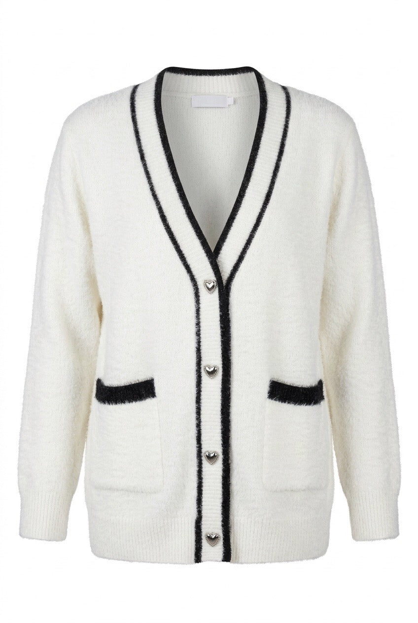 Vit cardigan med svarta kontrastdetaljer, hjärtknappar och bröstfickor, fotograferad framifrån | Caramelle Fashion | Lilla Hem
