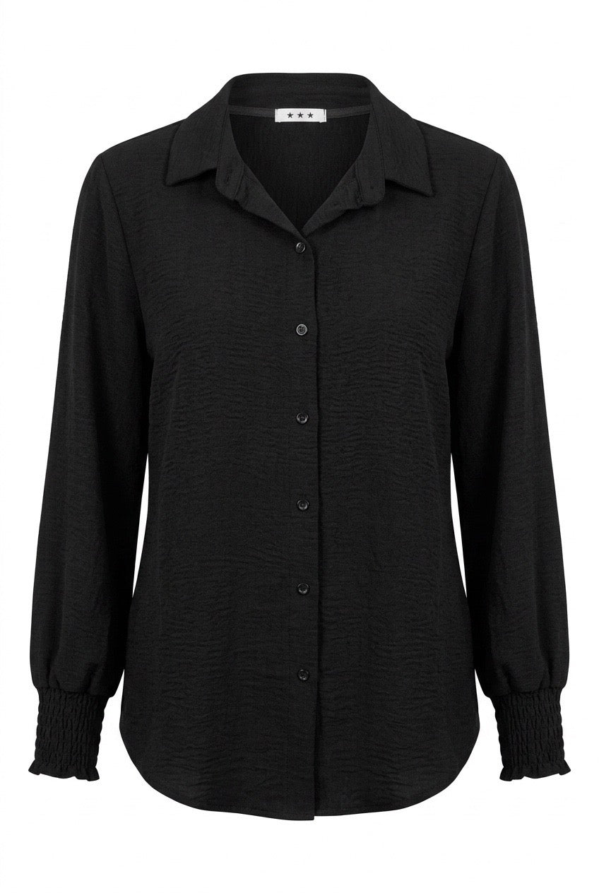 Svart skjortblus sedd framifrån med knappslå och smockade manchetter på långärmarna | Caramelle Fashion | Lilla Hem