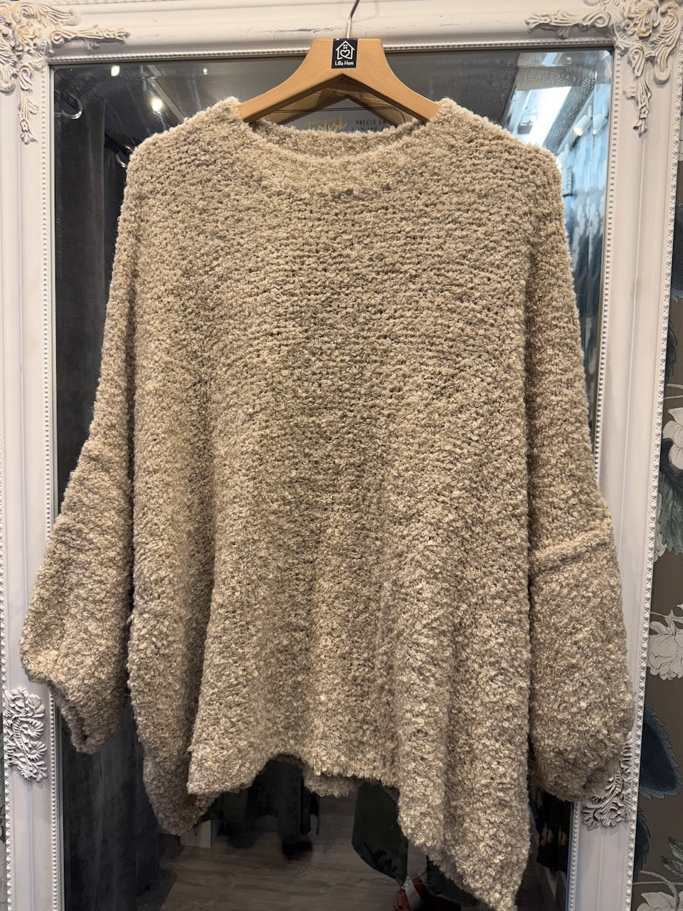 Beige stickad poncho med mjuk textur hängande på galge, framifrån | Jörlevik of Sweden | Lilla Hem