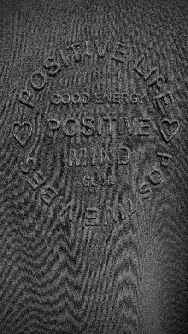 Närbild av puffbrodererad text och hjärtdetaljer på grå hoodie | Caramelle Fashion | Lilla Hem
