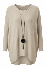 Beige ribbad oversized tröja framifrån med svart pompom-smycke och rundad längre bakkant | NEW&CO | Lilla Hem