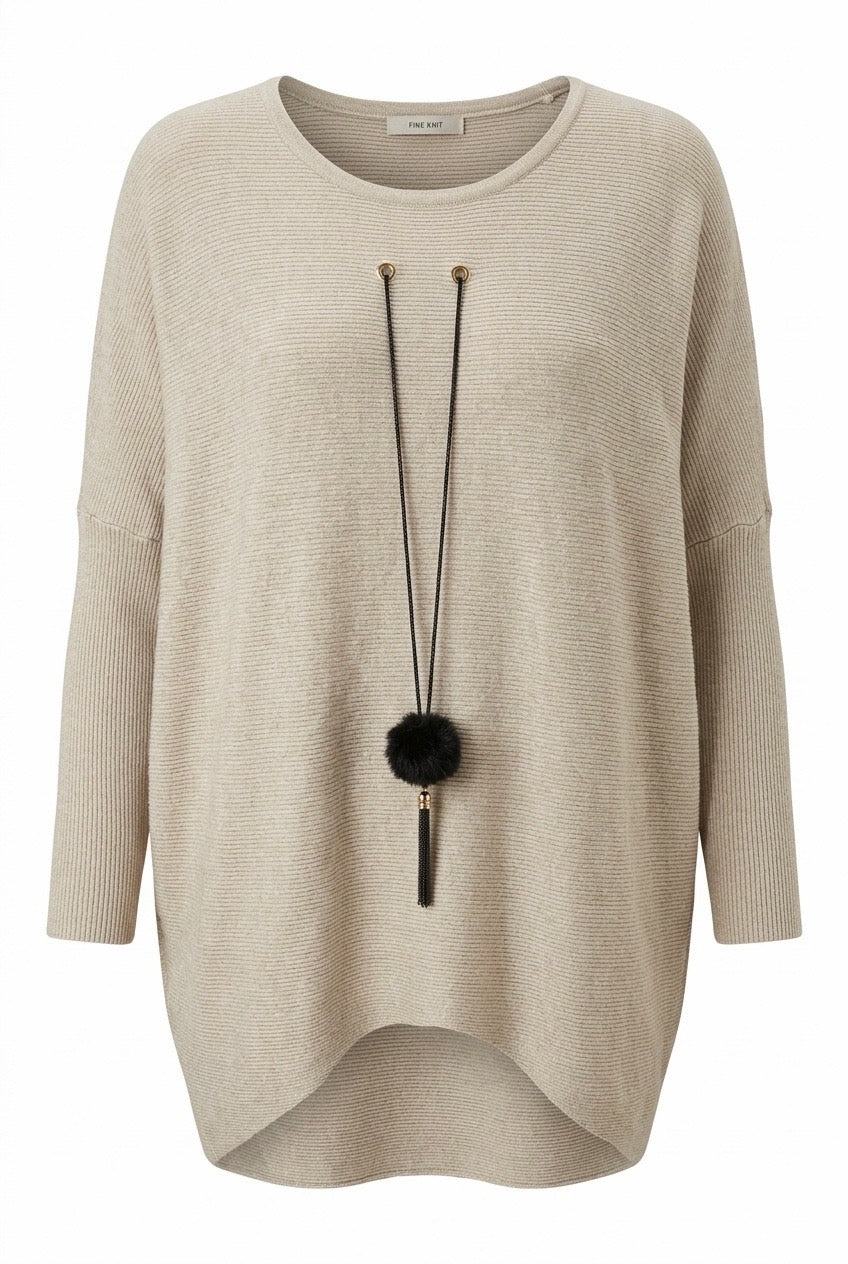 Beige ribbad oversized tröja framifrån med svart pompom-smycke och rundad längre bakkant | NEW&CO | Lilla Hem