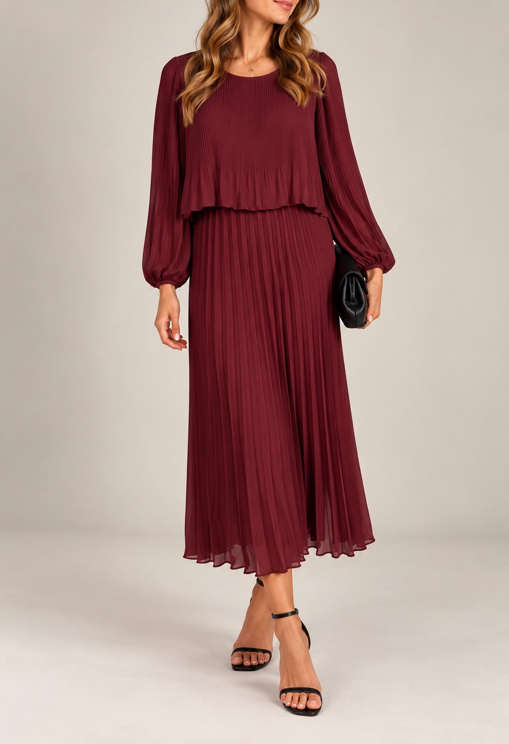Modell bär vinröd plisserad klänning med överdel framifrån, visande långärmad design och flöjande midi-längd | Caramelle Fashion | Lilla Hem