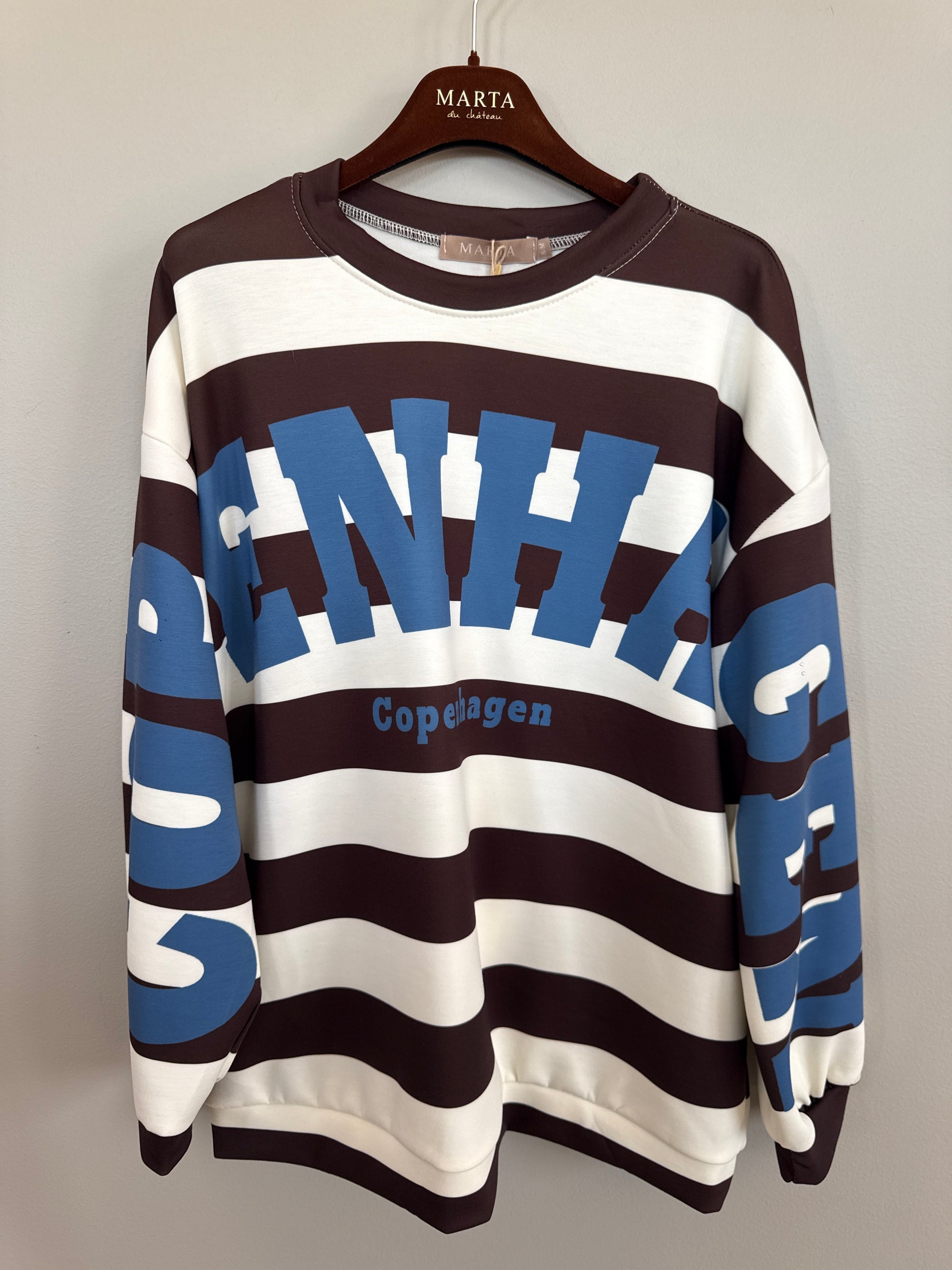 Sweatshirt med horisontella ränder i brunt, vitt och blått, stort texturtryck och "Copenhangen"-text, hängande på galge | MARTA du Chateau | Lilla Hem