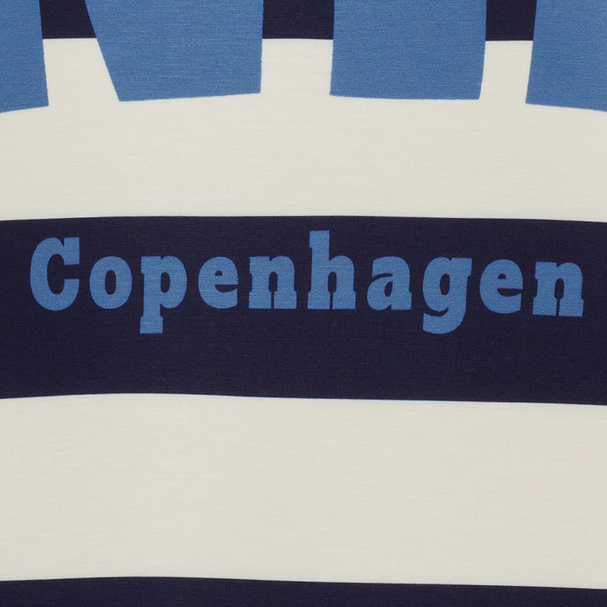Närbild av randigt sweatshirt-tyg med blå och marinblå horisontella ränder och text | MARTA du Chateau | Lilla Hem