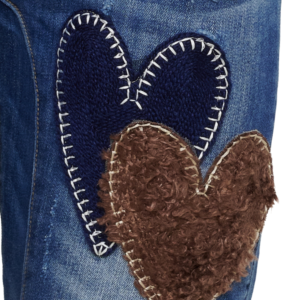 Närbild av appliqué med två hjärtan i marinblått och brunt med vit sömnad på jeanstyg | MARTA du Chateau | Lilla Hem