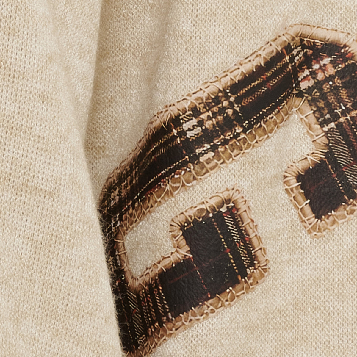 Närbild av sweatshirtens dekorativa applikation med fransar och mönster i svart och beige | MARTA du Chateau | Lilla Hem