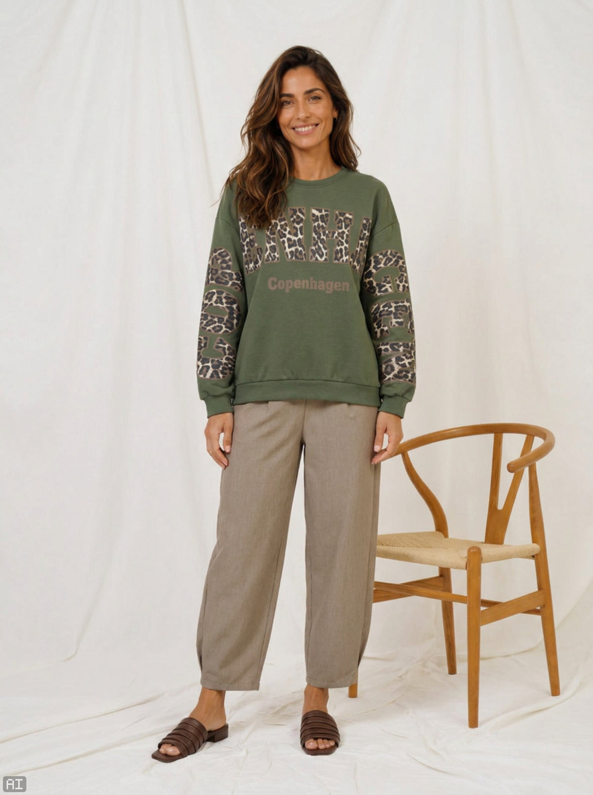 Modell bär grön sweatshirt med leopardmönster och "Copenhagen"-text, kombinerad med beiga byxor | MARTA du Chateau | Lilla Hem