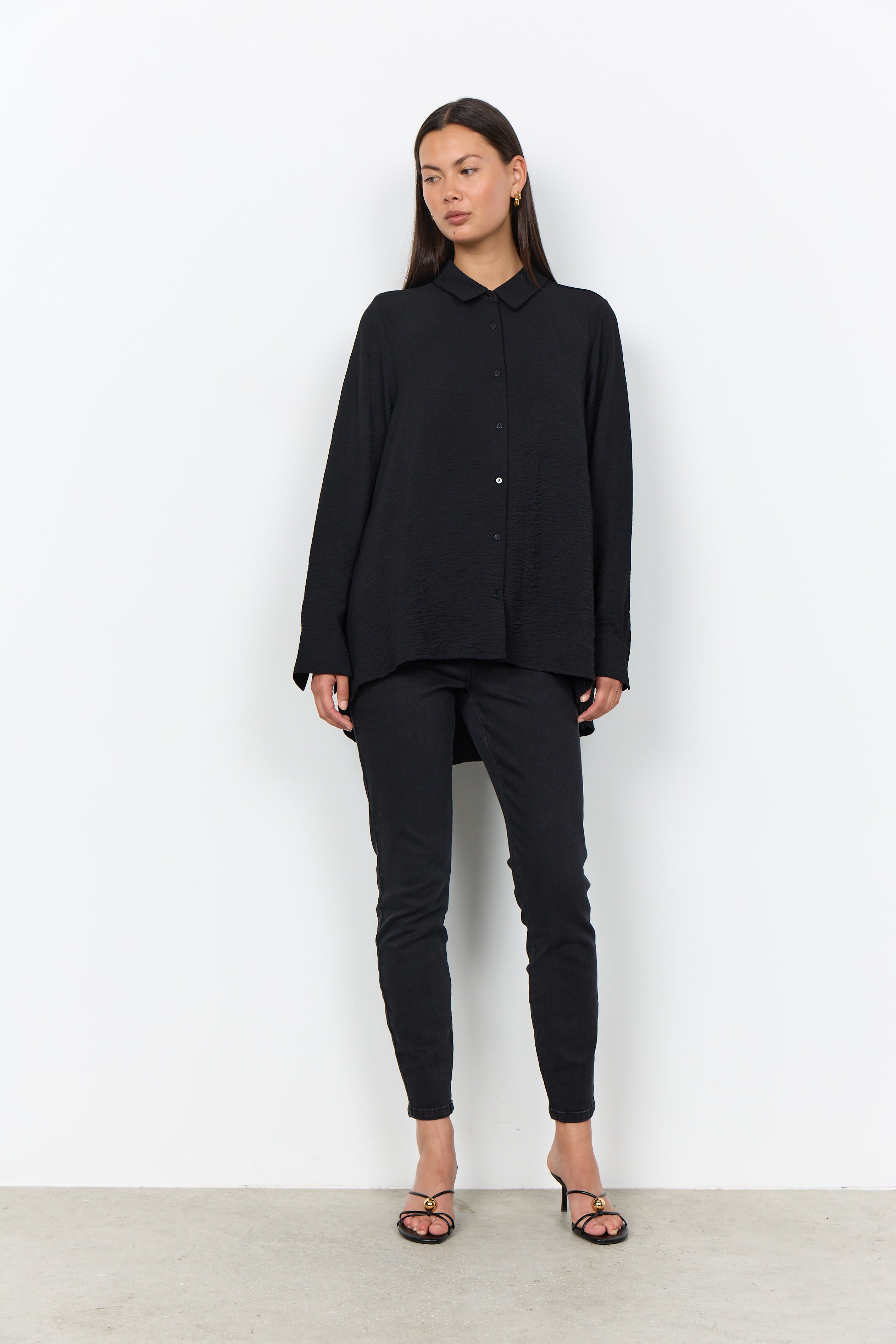 Modell bär svart skjorta med översize-passform och svarta jeans, framifrån | Soya Concept | Lilla Hem