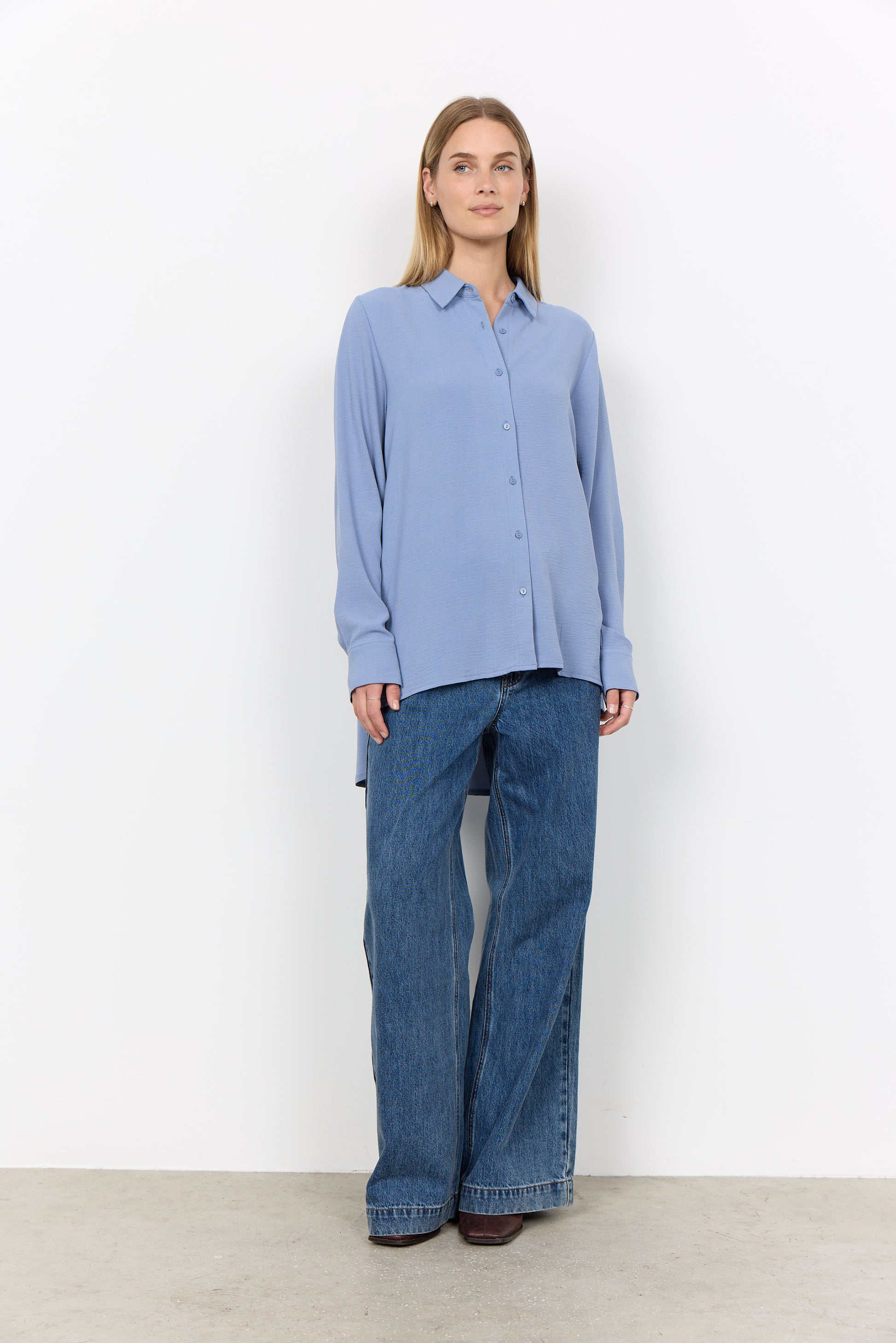 Modell bär ljusblå skjorta med knäppning och vida blåa jeans, sett framifrån | Soya Concept | Lilla Hem
