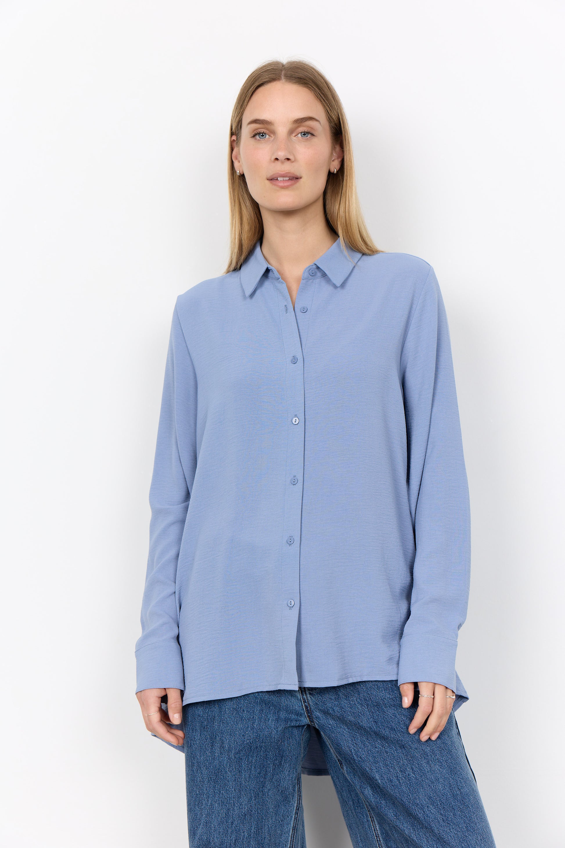 Modell bär ljusblå skjorta med knäppning framifrån, kombinerad med mörkblå jeans | Soya Concept | Lilla Hem