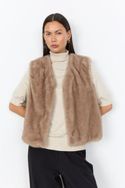 Modell bär beige pälsväst över vit polotröja, sett framifrån mot vit bakgrund | Soya Concept | Lilla Hem