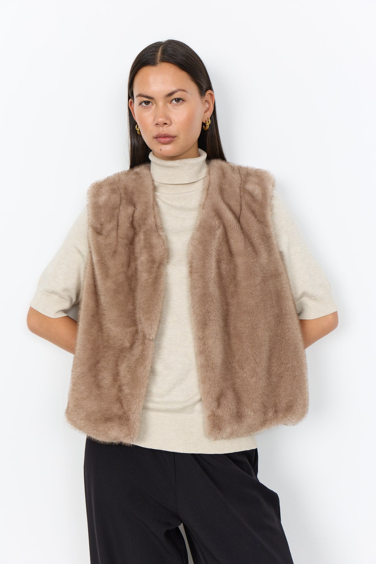 Modell bär beige pälsväst över vit polotröja, sett framifrån mot vit bakgrund | Soya Concept | Lilla Hem