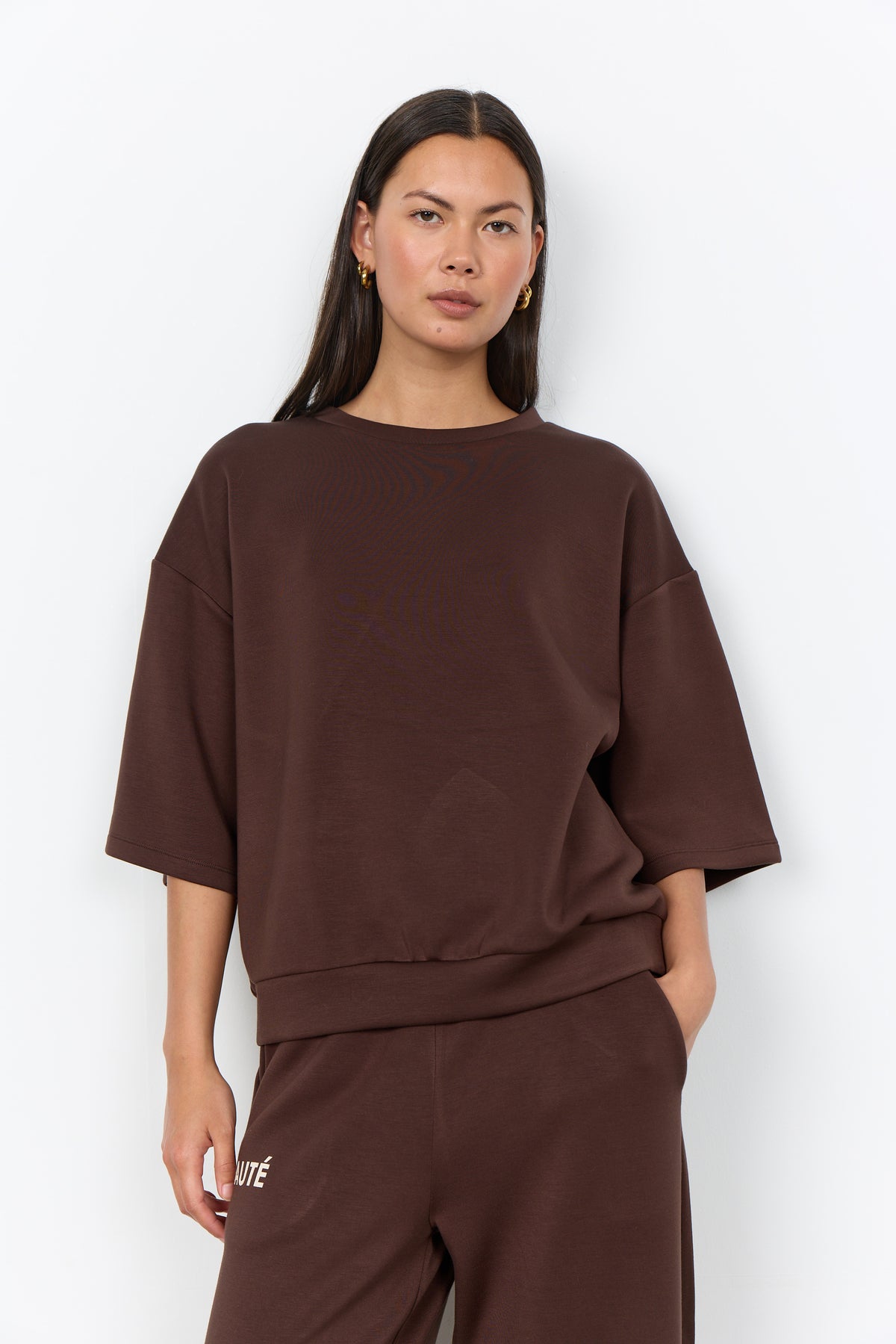 Modell bär mörkbrun sweatshirt med trekvarts ärmar och matchande byxor sett framifrån | Soya Concept | Lilla Hem