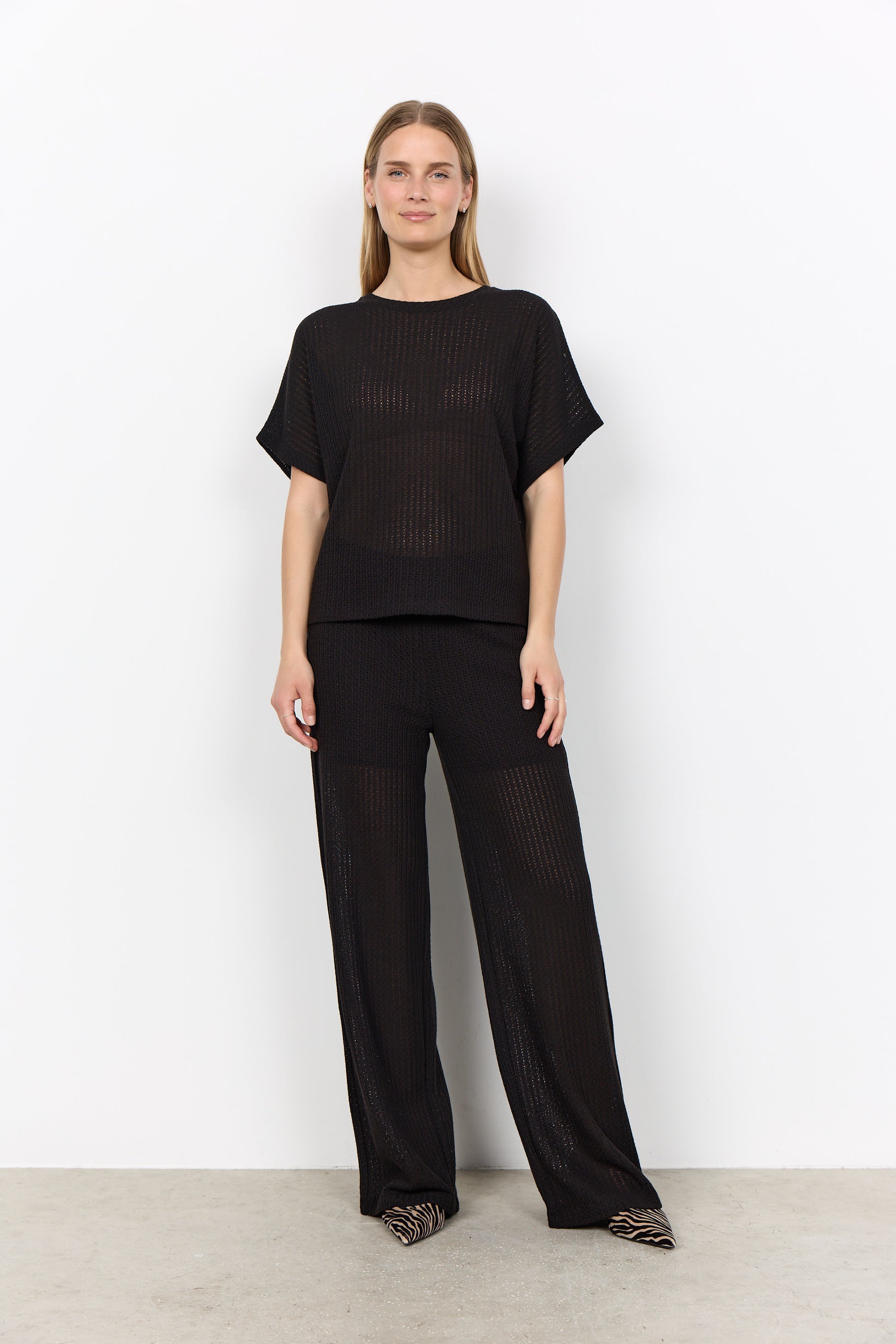 Modell bär svart ribbad set med kort t-shirt och vida byxor, sett framifrån | Soya Concept | Lilla Hem