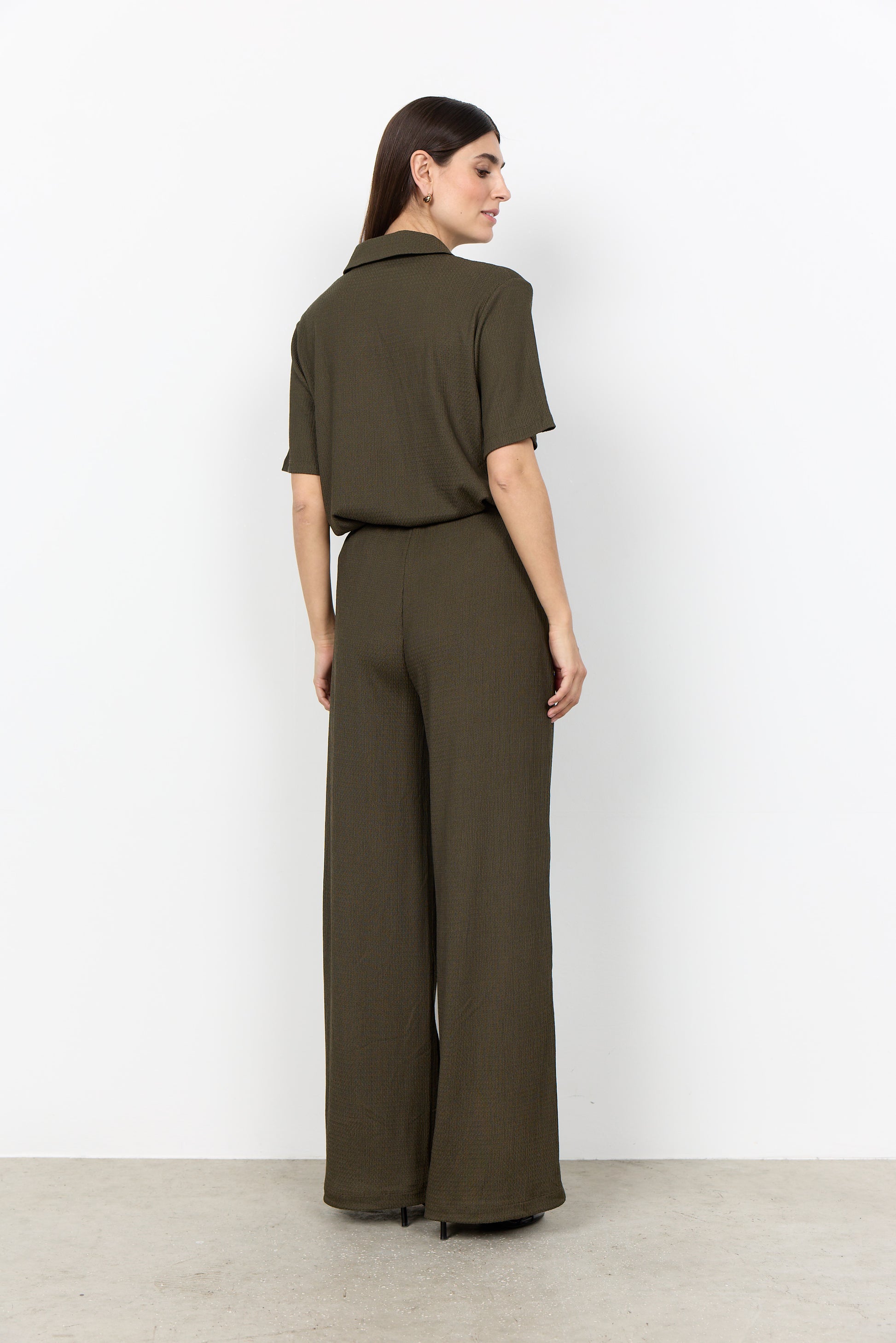 Modell bär olivgrön jumpsuit sett bakifrån med kort ärm och bred ben | Soya Concept | Lilla Hem