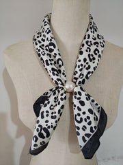 Scarf med leopardmönster i svart och vitt, knuten runt hals med pärldetalj, visad på klädningsmanikin | tim & simonsen | Lilla Hem