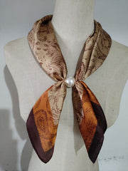 Scarf med paisleymönster i beige och brunt, knuten med pärla runt hals på mannekäng | tim & simonsen | Lilla Hem