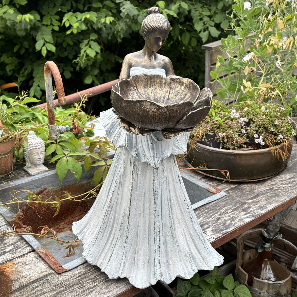 Trädgårdsfigur föreställande kvinna i plisserad klänning som håller en stor blomskål, fotograferad framifrån i | Trademan | Lilla Hem